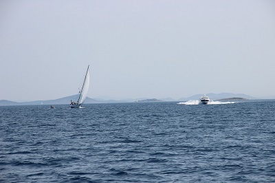 A powerboat is about to cross paths with a sailboat